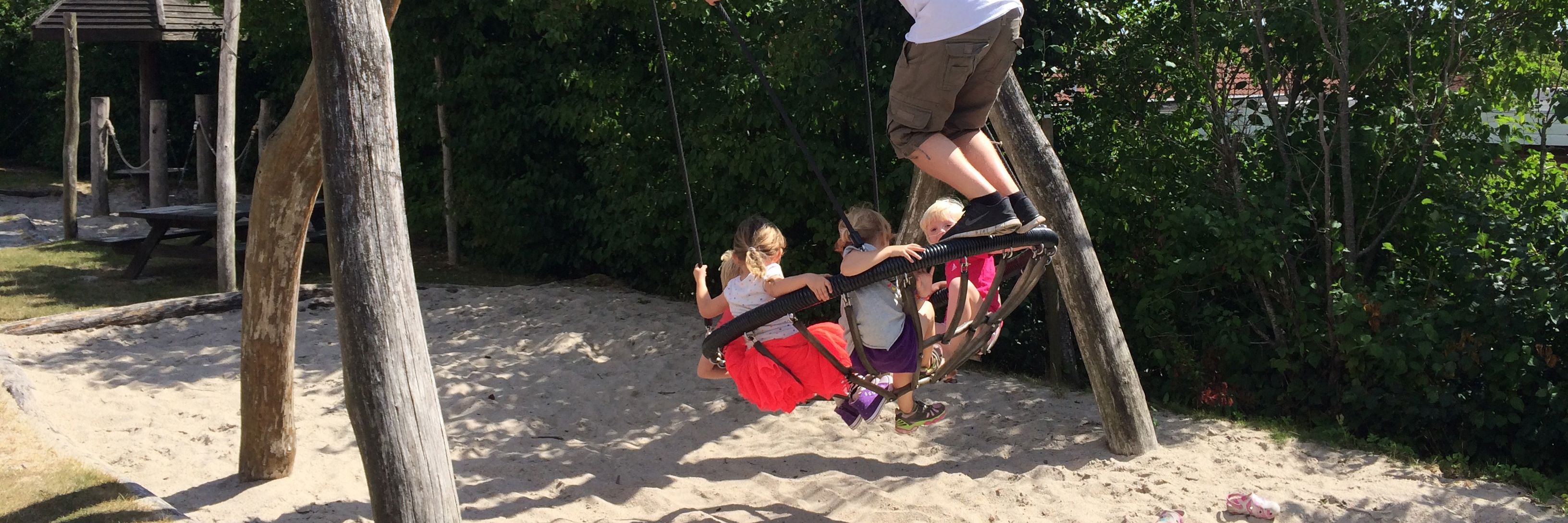 Børn og pædagog på legepladsen i Stjernehuset